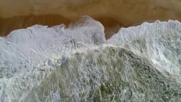 Portugal. Tiro aéreo de arriba hacia abajo de olas verdes espumosas del océano Atlántico rodando sobre la playa de arena. UHD — Vídeos de Stock