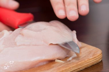 Bıçak, ahşap tahta üzerinde tavuk göğsü kesme kadın