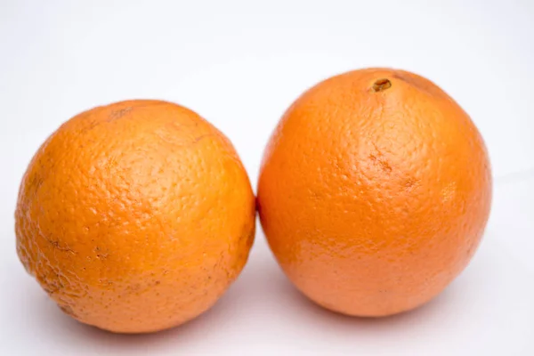 Beyaz arka plan üzerinde iki bütün ve soyulmamış portakal