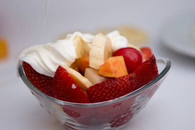 Beyaz arka plan üzerinde cam kapta hazırlanan meyve salat