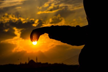 Güneş onun elleri durig tarafından Türkiye'de Istanbul şehir yukarıdaki günbatımı zaman tutan kız