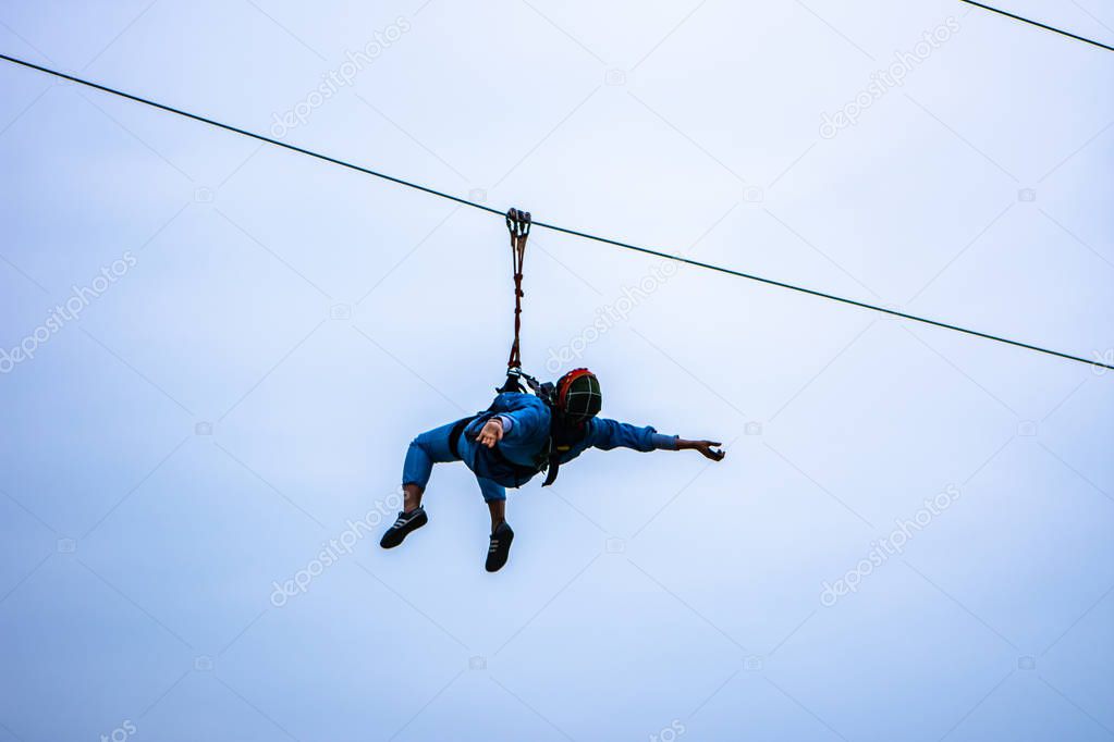Girl enjoying zip line high in the sky 