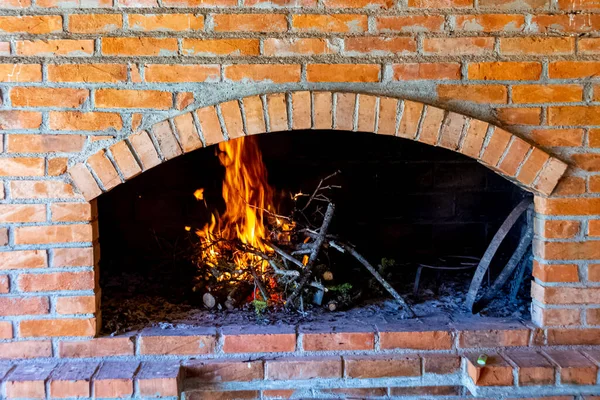 Branches are burning inside fireplace made of bricks — Stock Photo, Image