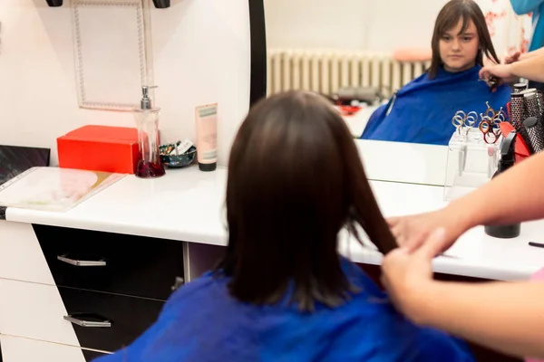Professionell kvinnlig frisör klippa flickor hår i salong — Stockfoto