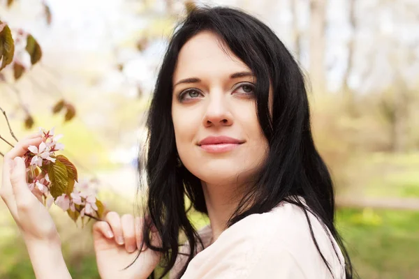 Livsstil och människor koncept: vacker ung kvinna i blomma trädgård — Stockfoto