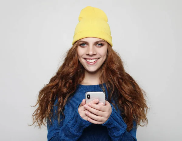 Estilo de vida, emocional e conceito de pessoas: Mulher encaracolada jovem com telefone inteligente — Fotografia de Stock