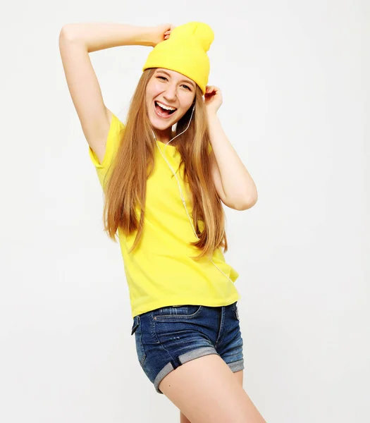 Menina de camiseta amarela dançando com expressão facial inspirada. Jovem ativa em roupa de verão casual se divertindo em casa . — Fotografia de Stock