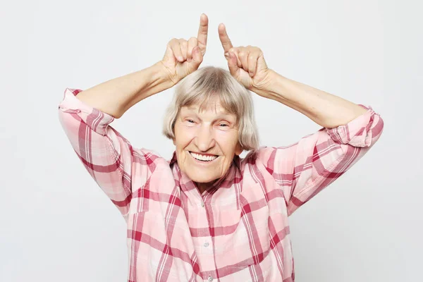 Stile di vita, emozione e concetto di persone: nonna invecchiata con il viso scioccato. Ritratto di nonna con camicia rosa . — Foto Stock