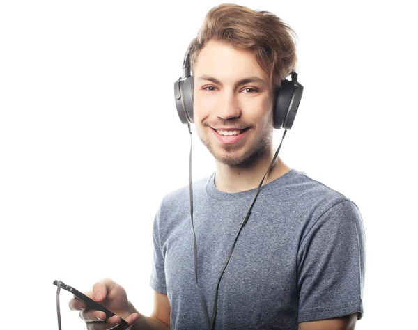 Homem segurando telefone celular e lambendo a música sobre fundo branco — Fotografia de Stock