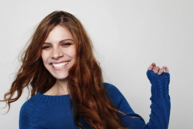 Modern örgü kap ve mavi jumper serin neşeli kıvırcık kız giyiyor.