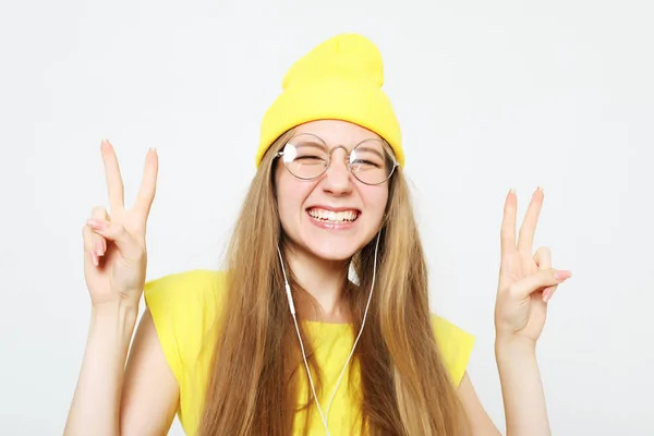 Mode cool meisje in koptelefoon luisteren naar muziek dragen gele hoed en t-shirt — Stockfoto