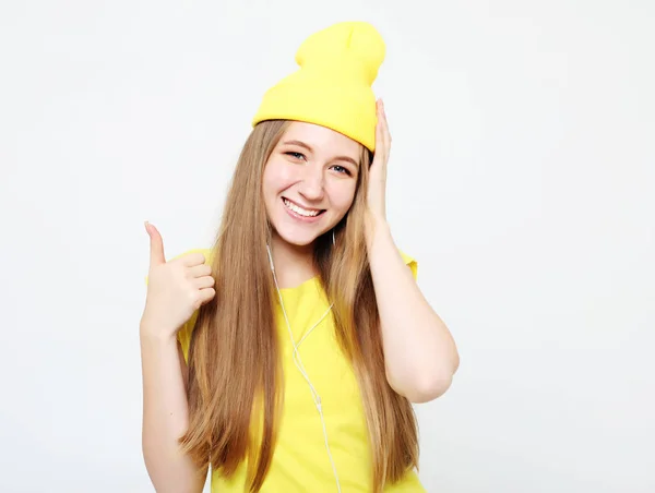 Lifestyle, emotion and people concept: Happy woman wearing yellow clothes giving thumb up — Stock Photo, Image