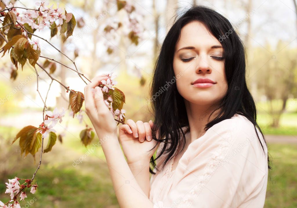 lifestyle and people concept: Beautiful woman in blossom garden