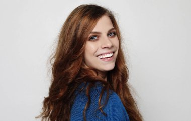 Modern örgü kap ve mavi jumper serin neşeli kıvırcık kız giyiyor