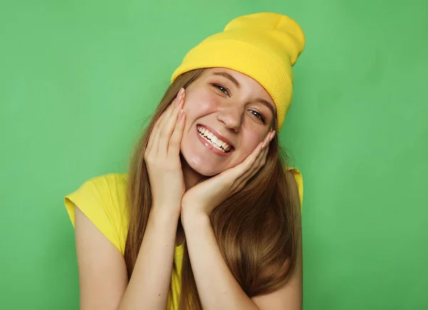 Mooie jonge vrouw die lacht om de camera op groene achtergrond — Stockfoto