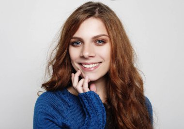 Çok güzel kadın kıvırcık saçlı kamera olmasının seyir heyecanlı ve mutlu yüz ifadesi, boş stüdyo duvar karşı