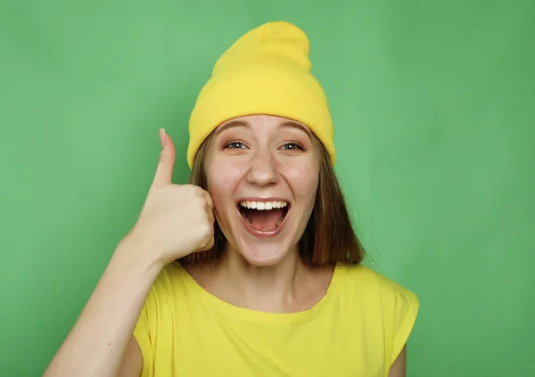 Estilo de vida, emoção e conceito de pessoas: mulher feliz vestindo roupas amarelas dando polegar para cima — Fotografia de Stock