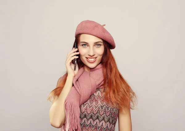 Portret van een jonge vrouw die het dragen van roze outfit praten op mobiele telefoon — Stockfoto