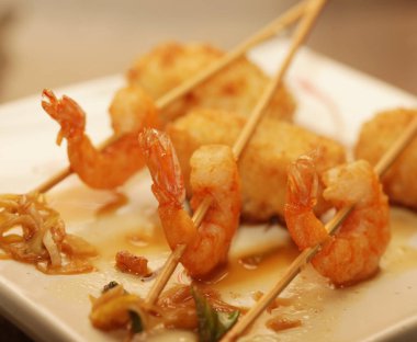 Beyaz tabakta pilavlı ızgara karides.