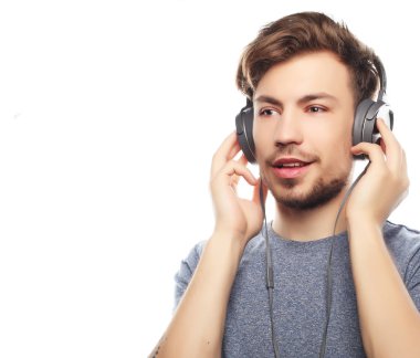 Kulaklıklar giyen ve ayakta gülümseyen yakışıklı delikanlı