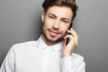mutlu iş adam ile onun smartphone gri bac karşı arıyor