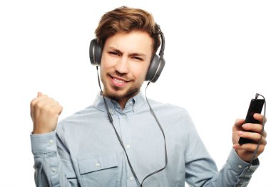 Kulaklık takıp müzik dinleyen yakışıklı bir genç..