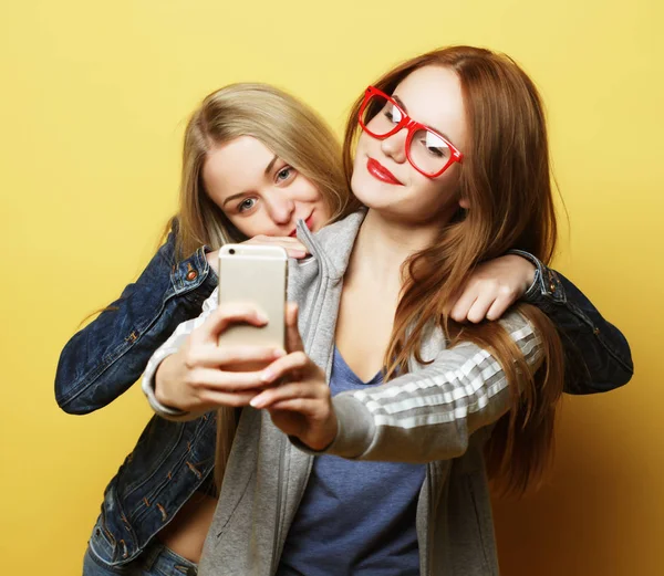 Zwei Freundinnen im Hipster-Outfit machen Selfie auf dem Handy — Stockfoto
