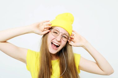 Beyaz arka plan üzerinde sarı hat ve t-shirt giyen müzik dinlerken kulaklık oldukça serin kız moda