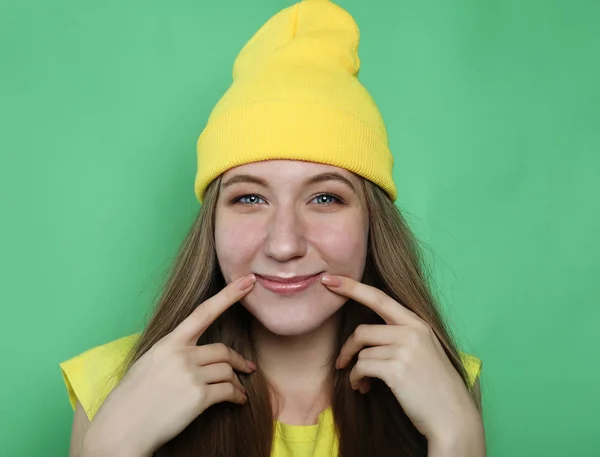 Mooie jonge vrouw die lacht om de camera op groene achtergrond — Stockfoto