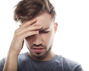  Genç iş adamı kafasına dokunuyor ve gözlerini kapalı tutuyor.