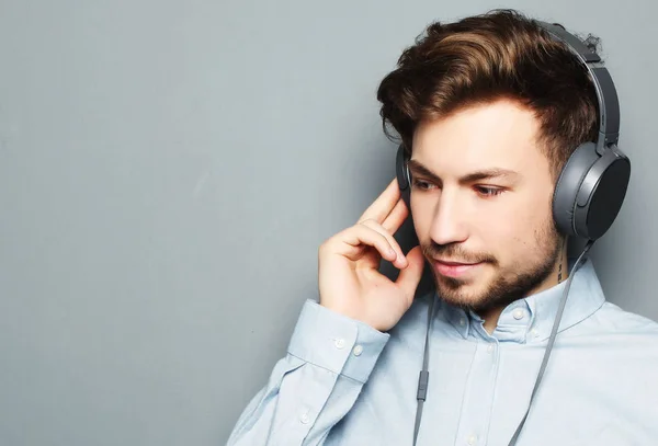 Beau jeune homme portant des écouteurs et écoutant de la musique . — Photo