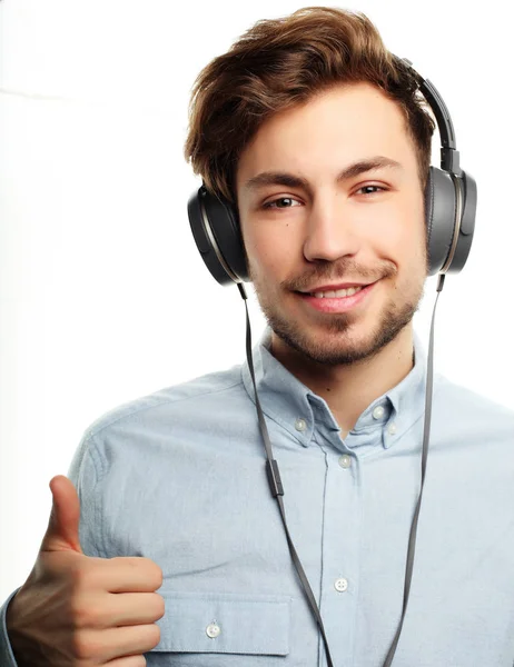 Bonito jovem vestindo fones de ouvido e ouvindo música . — Fotografia de Stock