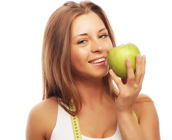 Sport, strava, zdraví a lidé koncept: Mladá veselá žena ve sportovním oblečení s jablkem, izolované přes bílé pozadí — Stock fotografie