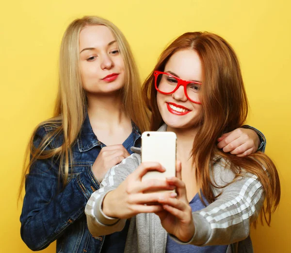 Dvě dospívající dívky přátelé v hipster oblečení, aby selfie na telefonu — Stock fotografie