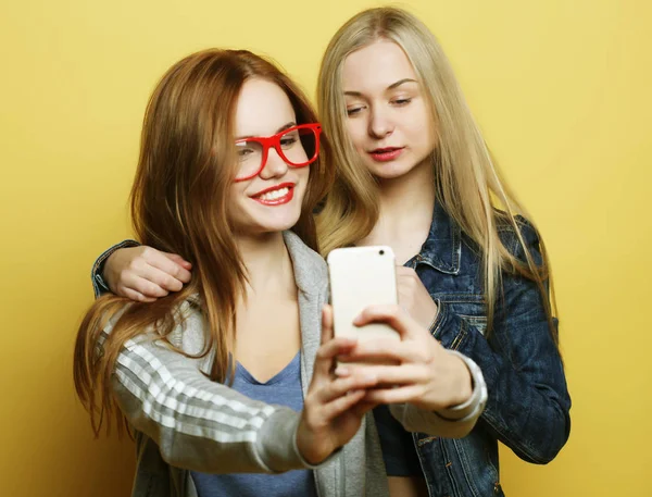 Due ragazze adolescenti amiche in abito hipster fanno selfie su un telefono — Foto Stock