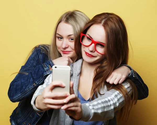 Twee tiener meisjes vrienden in hipster outfit maken selfie op een telefoon — Stockfoto