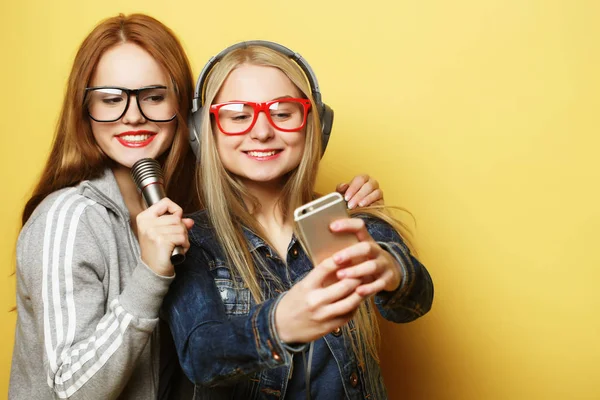 Twee meisjes met een microfoon zingen en plezier hebben samen, maken selfie — Stockfoto