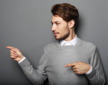 Genç ve yakışıklı bir işadamı parmağıyla işaret ediyor.