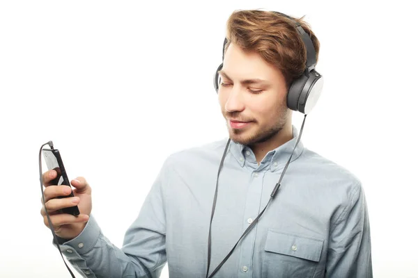 Beau jeune homme portant des écouteurs et écoutant de la musique . — Photo