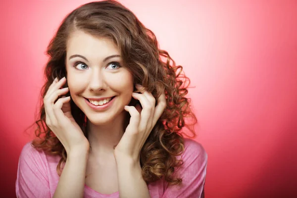 Junge schöne Frau mit lockigem Haar über rosa Hintergrund — Stockfoto