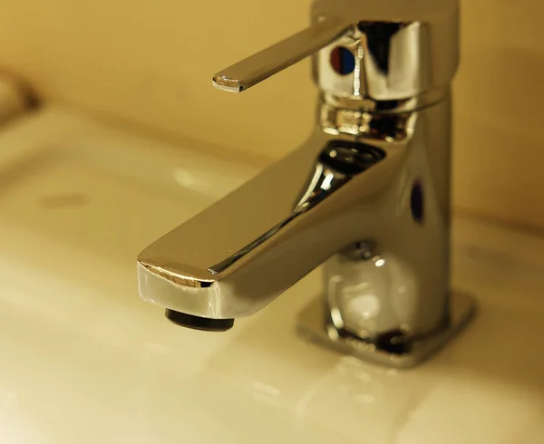 Robinet de salle de bain moderne, photo rapprochée, tons chauds — Photo
