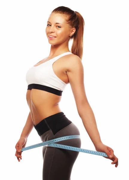 Close-up of a woman in sportswear measuring her waist — Stock Photo, Image