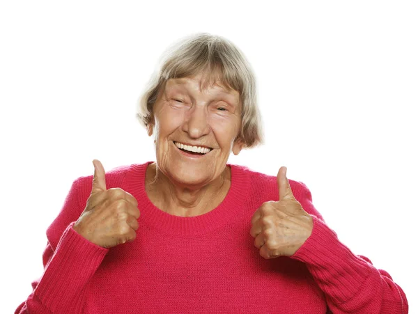 Elderly woman giving a thumb up and looking at the camera — Stock Photo, Image