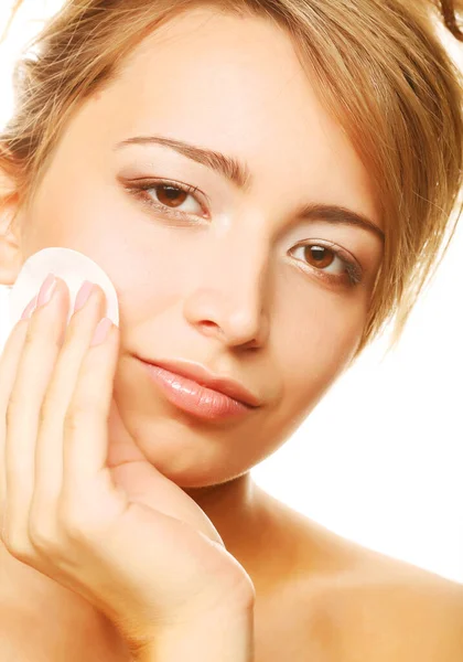 Giovane donna pulisce una pelle del viso isolata su sfondo bianco — Foto Stock