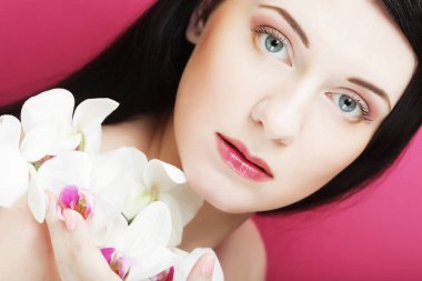 Orkide çiçekli güzel, sağlıklı bir kadın. Kapat.