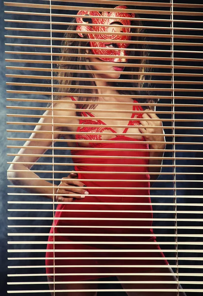 Mujer atractiva en rojo con máscara — Foto de Stock