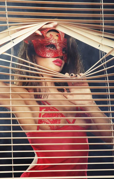 Mujer atractiva en rojo con máscara — Foto de Stock