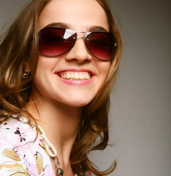 Mujer con gafas de sol sobre fondo gris —  Fotos de Stock