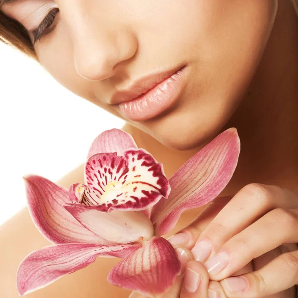 SPA, menina bonita segurando flor de orquídea em suas mãos — Fotografia de Stock