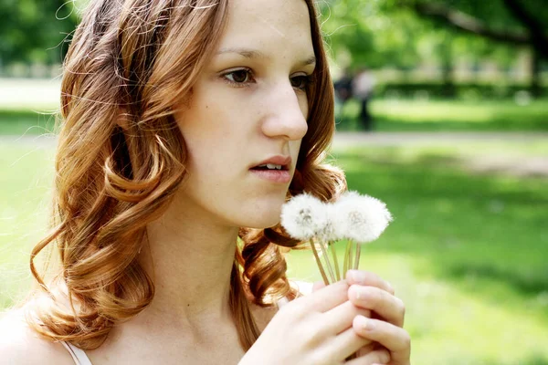 Mujer joven con flores en el parque de verano, feliz día de verano —  Fotos de Stock